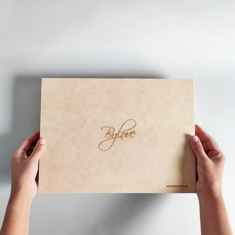 Caja con tapa de regalo y logotipo grabado en letra manuscrita, hecha para By Love